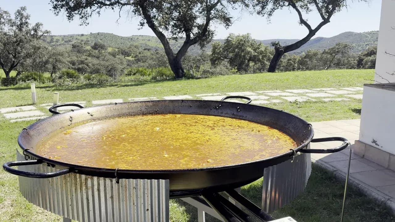 Rice cooking in a paella pan outdoors